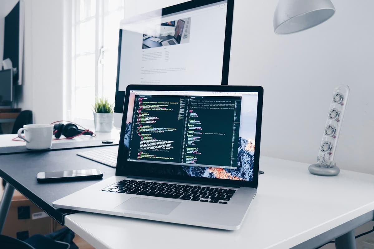 MacBook on a desk showing a code editor